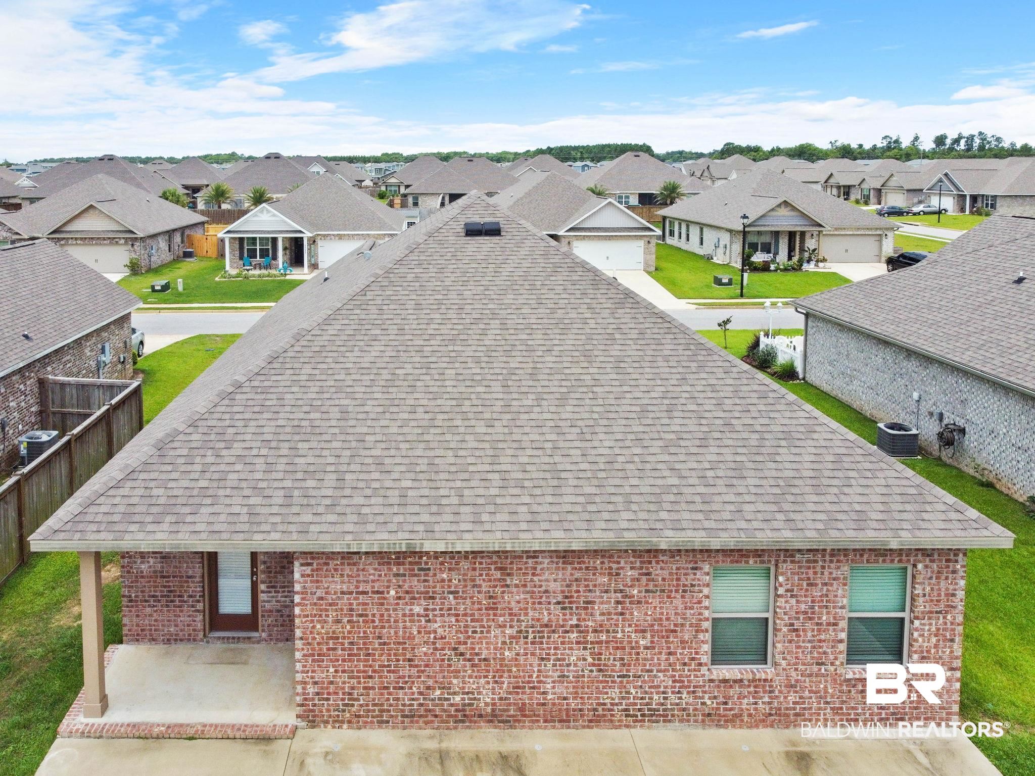 1710 Grouse Street Foley, AL 36535 - Photo 74 of 76 Aerial perspective featuring a red brick exterior, shingle roof, and a covered back patio with concrete flooring
