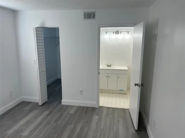 an empty room with wooden floor and mirror