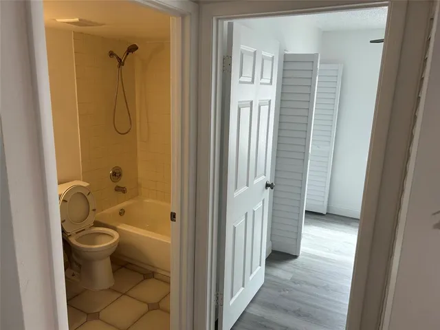 a bathroom with a granite countertop bathtub shower and toilet