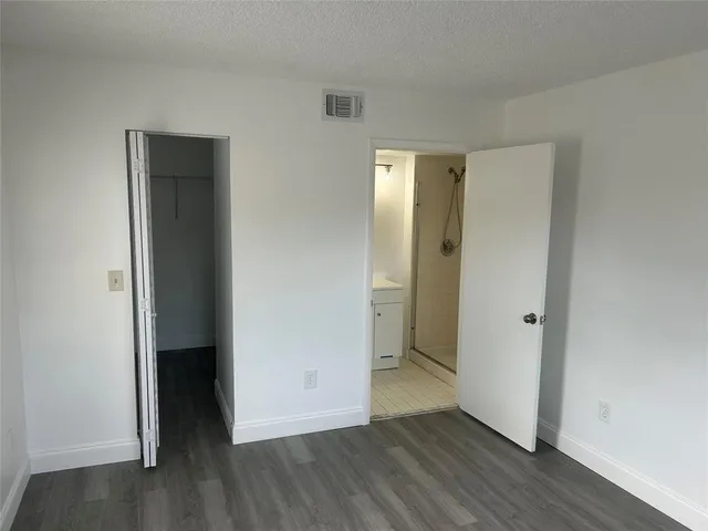 an empty room with wooden floor and closet