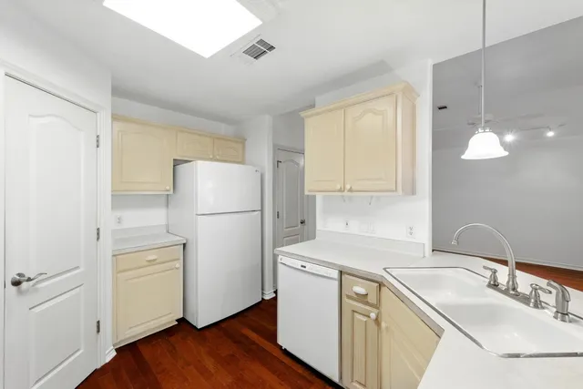 a kitchen with a sink a refrigerator a window and cabinets