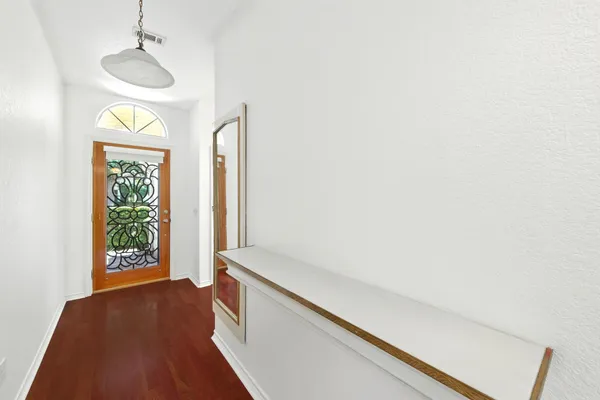 a hallway with sliding door and chandelier