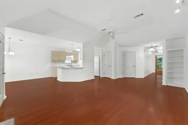 a view of kitchen and hall with wooden floor and a cabinet