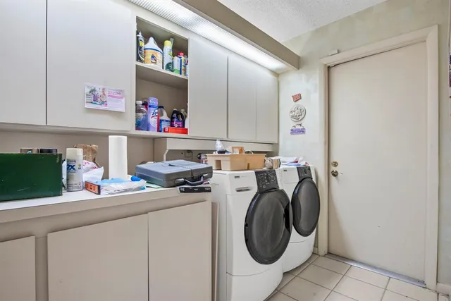 a utility room with dryer washer and a fridge