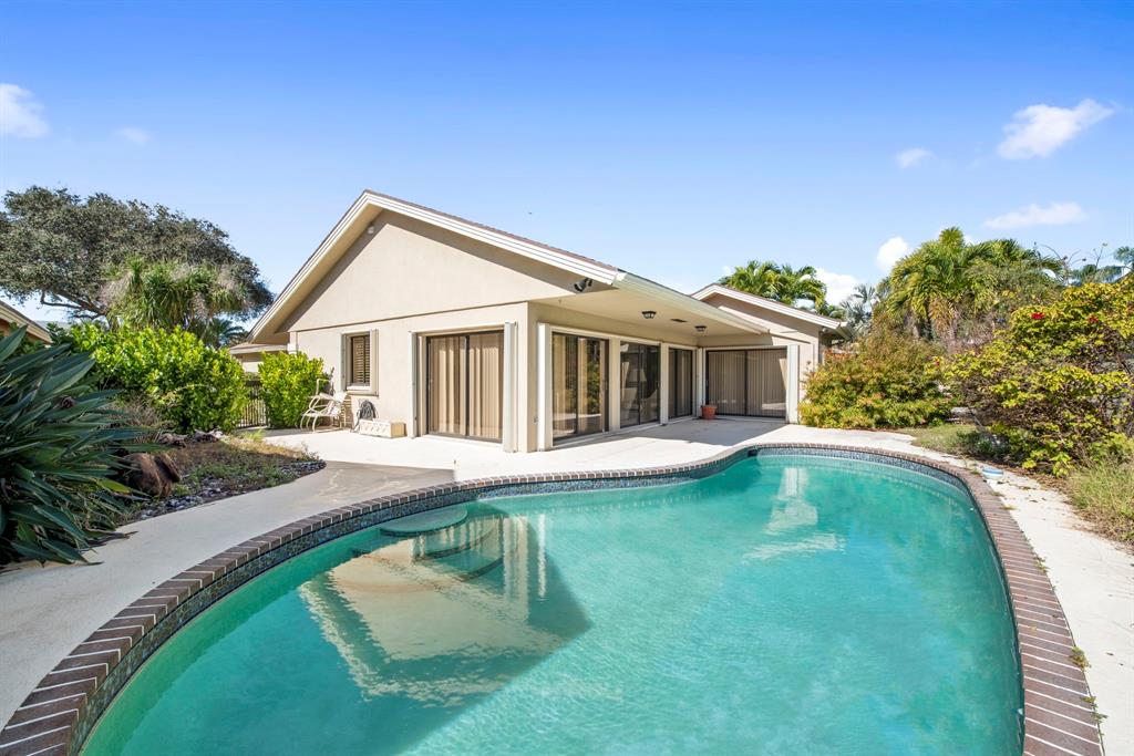 119 Beach Summit Court Jupiter, FL 33477 - Photo 14 of 23 a front view of a house with a yard table and chairs