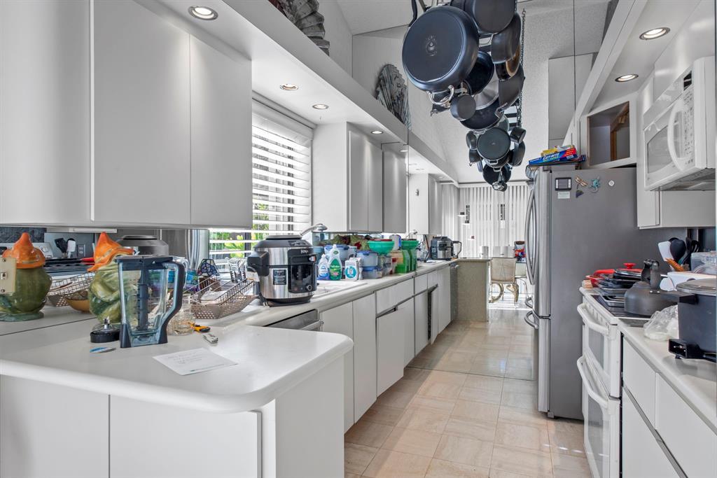 119 Beach Summit Court Jupiter, FL 33477 - Photo 7 of 23 a kitchen filled with a white stove top oven and cabinets