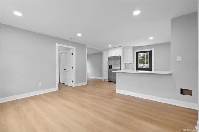 a view of empty room with wooden floor and window