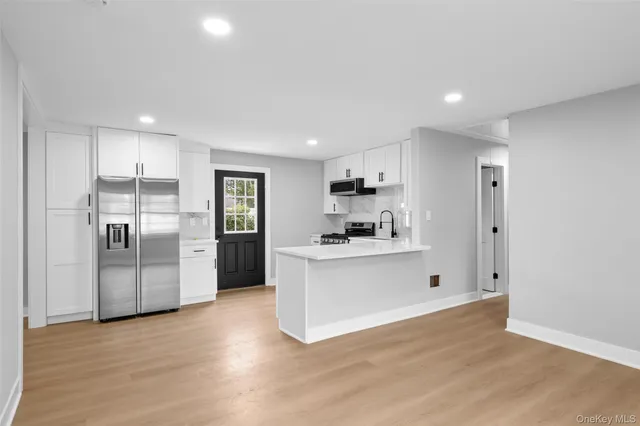 a large kitchen with stainless steel appliances a refrigerator and a stove top oven