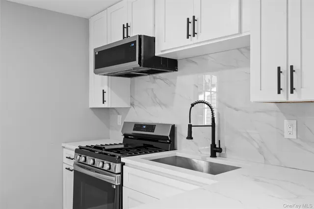 a kitchen with stainless steel appliances a sink a stove and cabinets