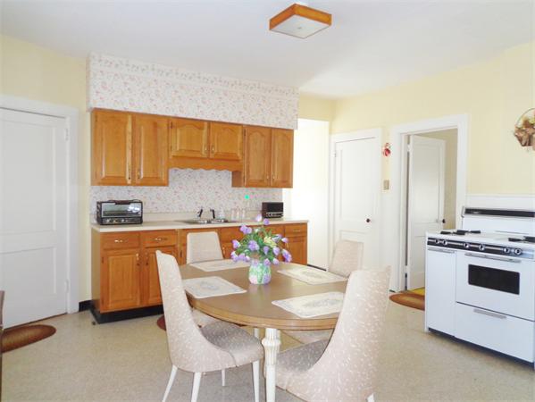 17-23 North Street Three Rivers, MA 01080 - Photo 8 of 29 a kitchen with stainless steel appliances a stove a sink a microwave a refrigerator and white cabinets with wooden floor