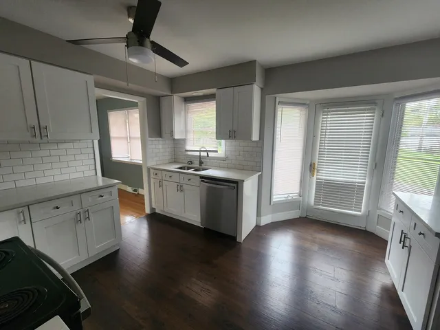 a kitchen with stainless steel appliances granite countertop a stove a sink and a large window