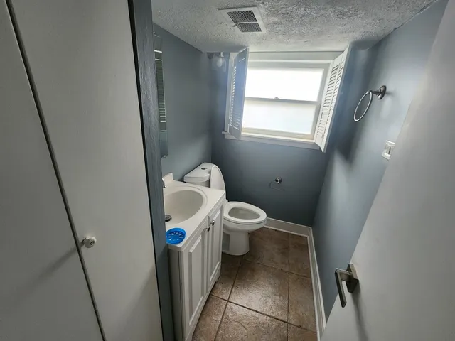 a white toilet sitting next to a sink a small yard