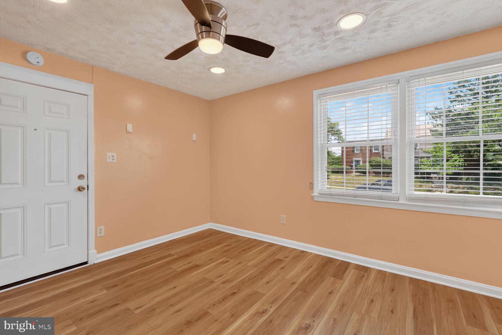 2437 Iverson Street Temple Hills, MD 20748 - Photo 3 of 15 a view of an empty room with wooden floor and a window