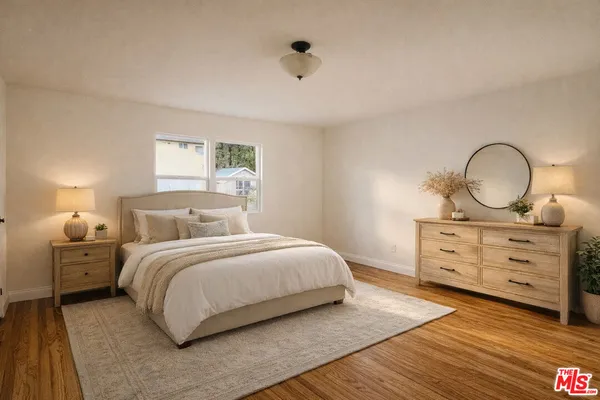 a bedroom with a bed and wooden floor