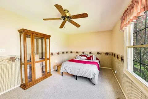 a bedroom with a bed and a ceiling fan