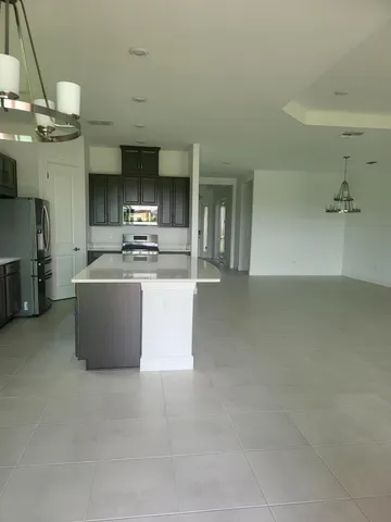 a view of a kitchen with a sink and dishwasher a fireplace with wooden floor