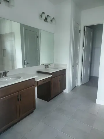 a spacious bathroom with a granite countertop sink and a mirror
