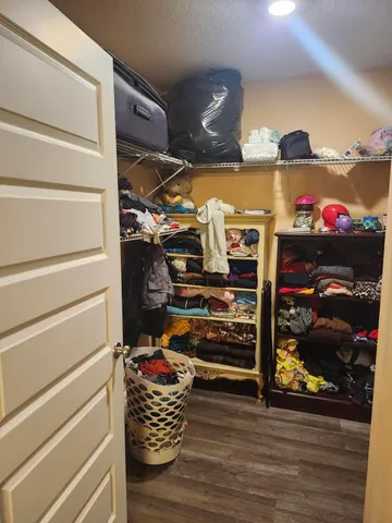 a view of walk in closet with clothes and shoes
