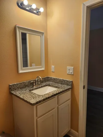 a bathroom with a granite countertop sink and a mirror