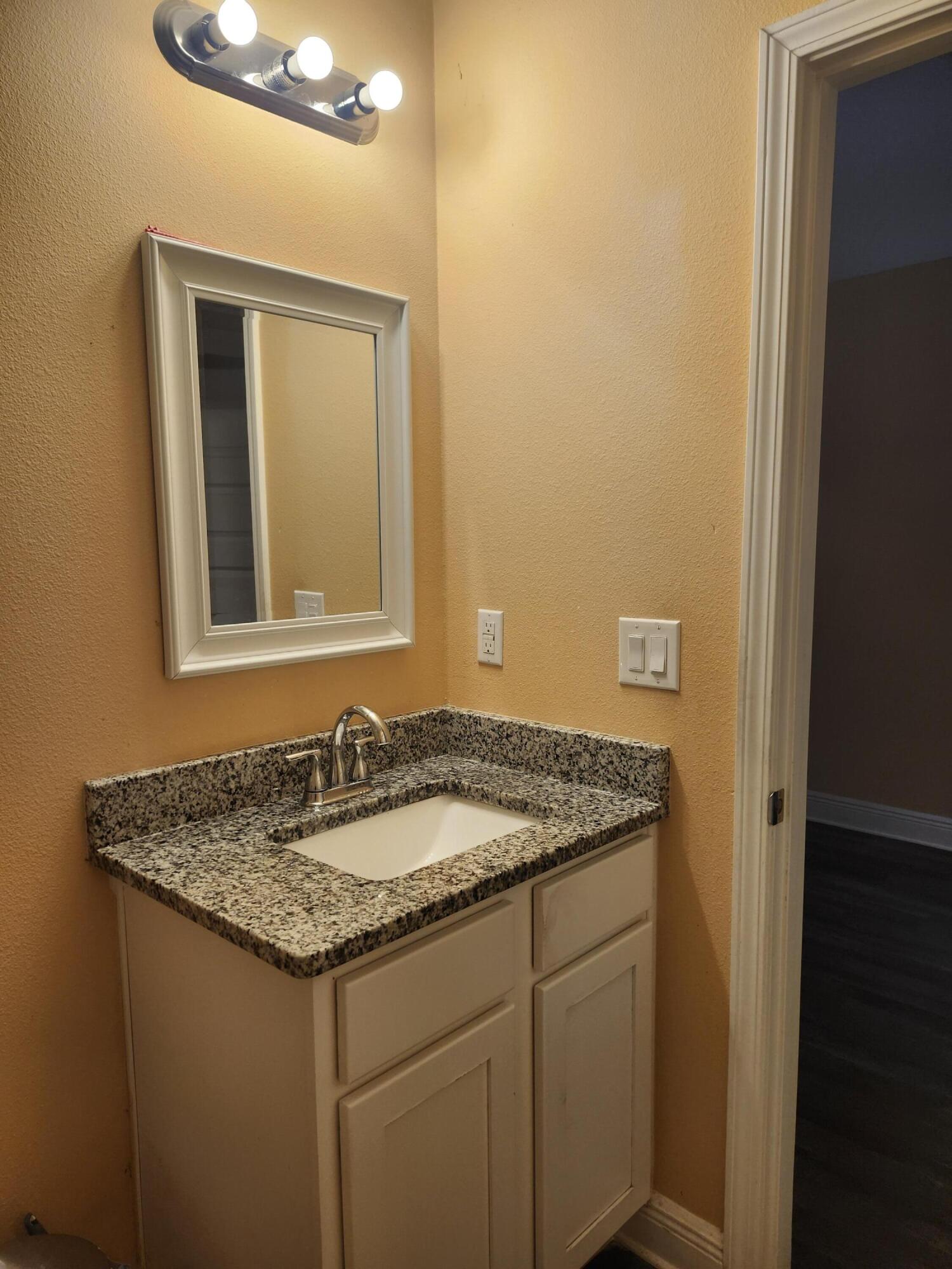 167 Apache Drive DeFuniak Springs, FL 32435 - Photo 4 of 18 a bathroom with a granite countertop sink and a mirror