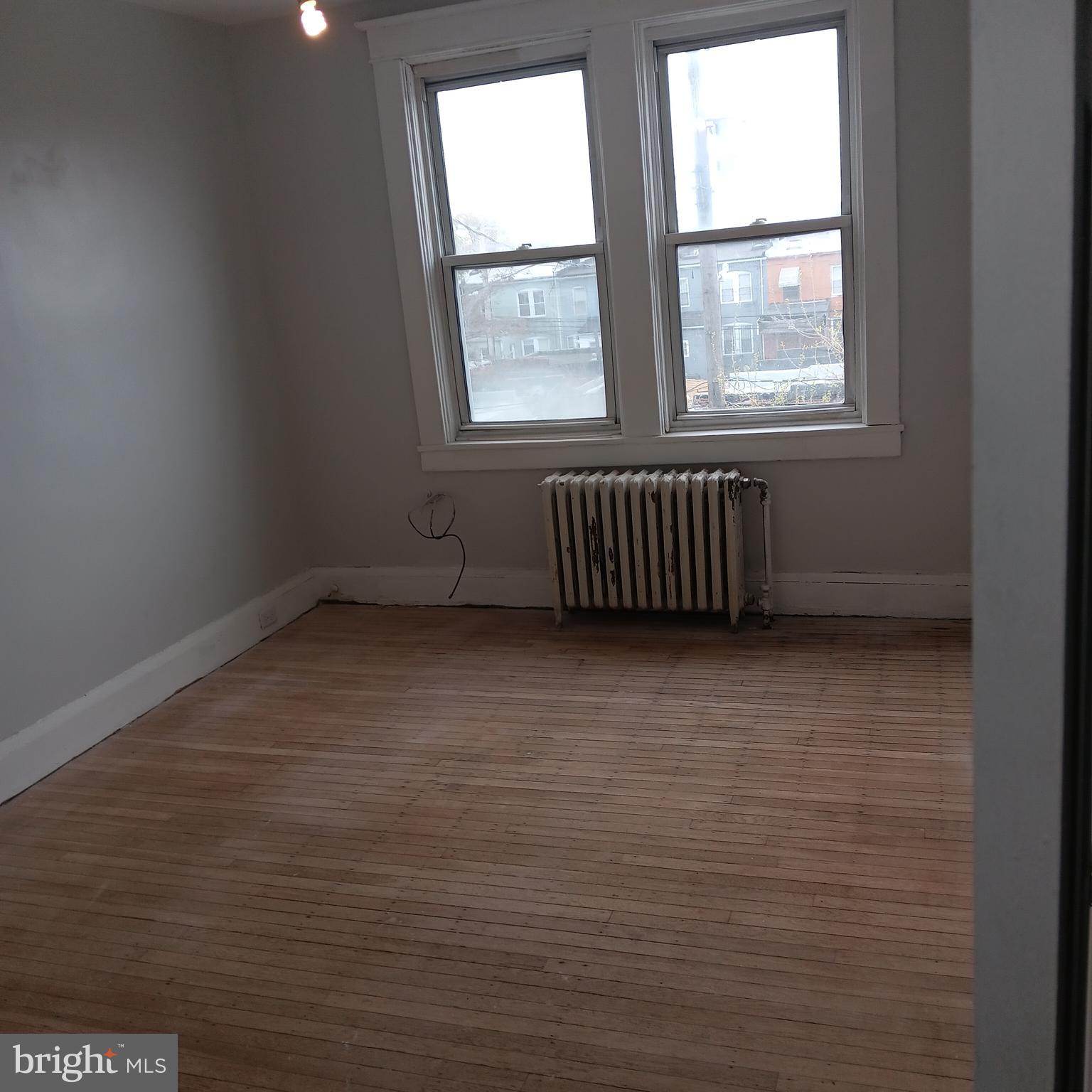 2419 Mosher Street Baltimore, MD 21216 - Photo 8 of 19 an empty room with wooden floor and windows