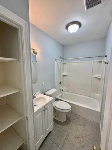 a bathroom with a granite countertop sink toilet mirror and bathtub