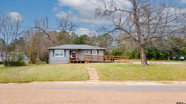 a view of a house with a big yard and large trees