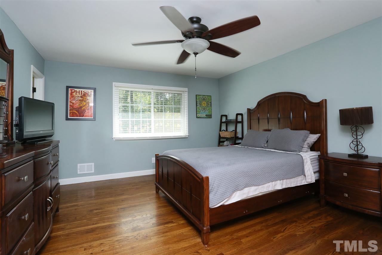 7101 Tanbark Way Raleigh, NC 27615 - Photo 17 of 25 a bedroom with a bed and a flat tv screen on dresser