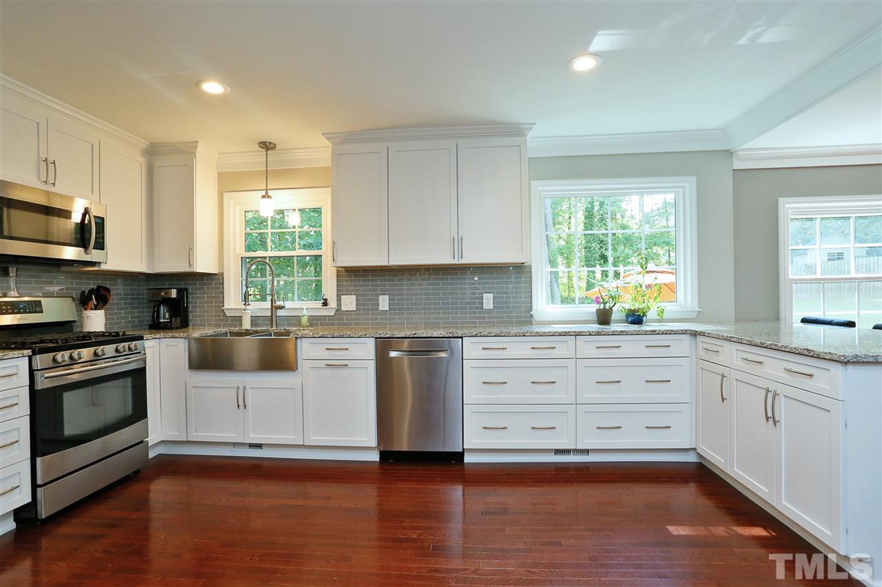 7101 Tanbark Way Raleigh, NC 27615 - Photo 4 of 25 a kitchen with granite countertop white cabinets and appliances
