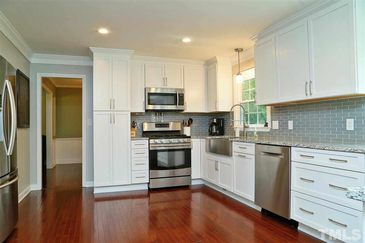 7101 Tanbark Way Raleigh, NC 27615 - Photo 5 of 25 a kitchen with a refrigerator stove and wooden cabinets