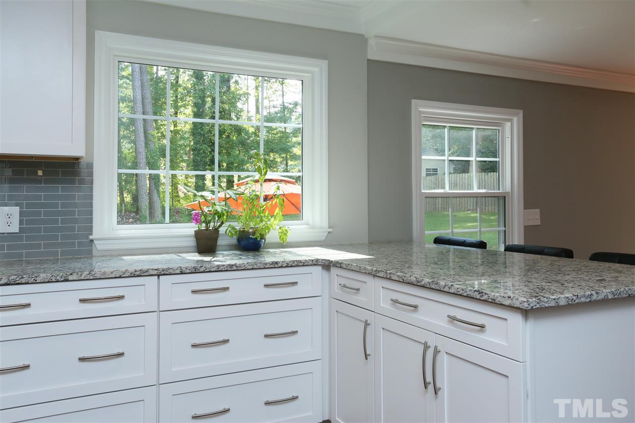 7101 Tanbark Way Raleigh, NC 27615 - Photo 9 of 25 a kitchen with granite countertop cabinets and window