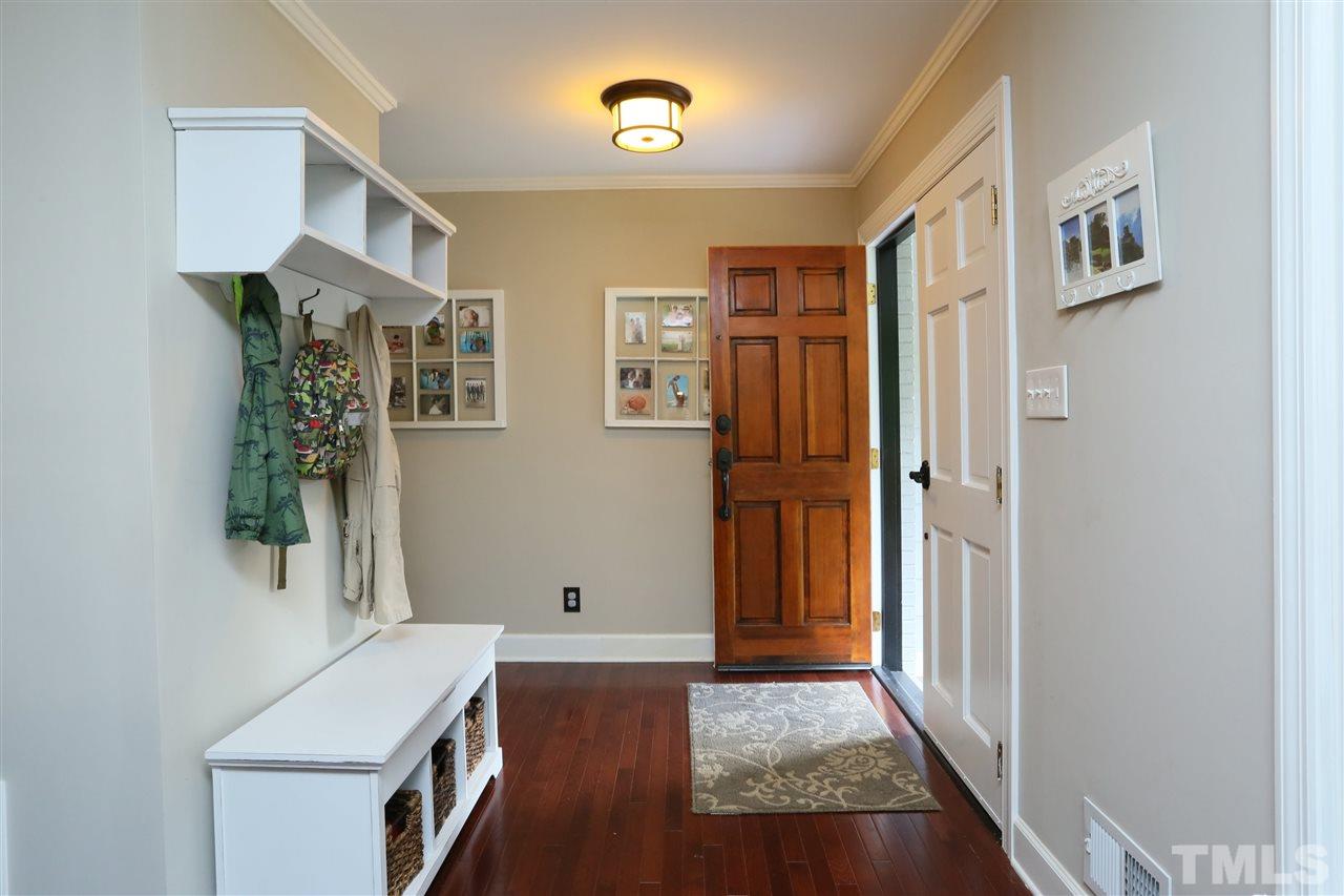 7101 Tanbark Way Raleigh, NC 27615 - Photo 10 of 25 a view of a hallway with entryway wooden floor and front door