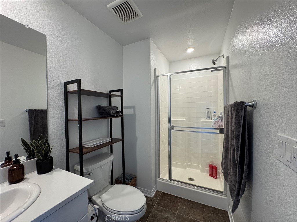 19167 Sequoia Grv Street Riverside, CA 92507 - Photo 7 of 30 a bathroom with a toilet a sink and shower