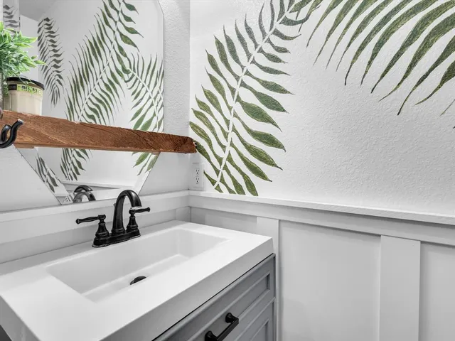 a bedroom with a bed a large window with table and chairs