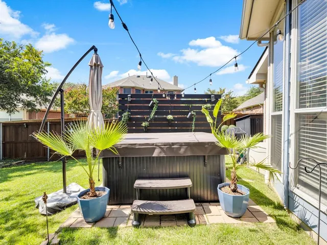 a view of a big yard with table and chairs under an umbrella