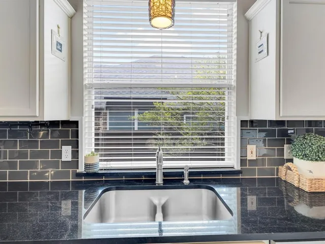 a kitchen with stainless steel appliances a sink a table and chairs in it
