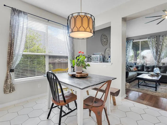 a kitchen with stainless steel appliances granite countertop a table and chairs in it