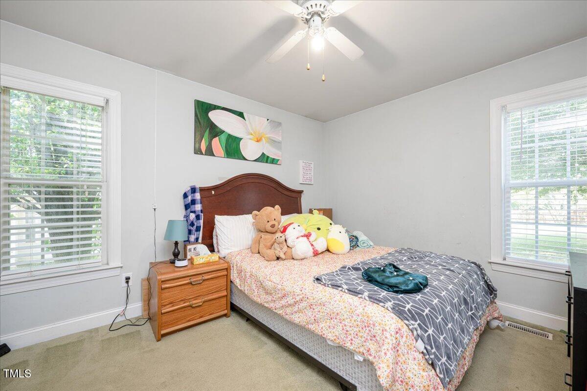 604 Sinewell Drive Wake Forest, NC 27587 - Photo 17 of 25 a bedroom with a bed and a chandelier