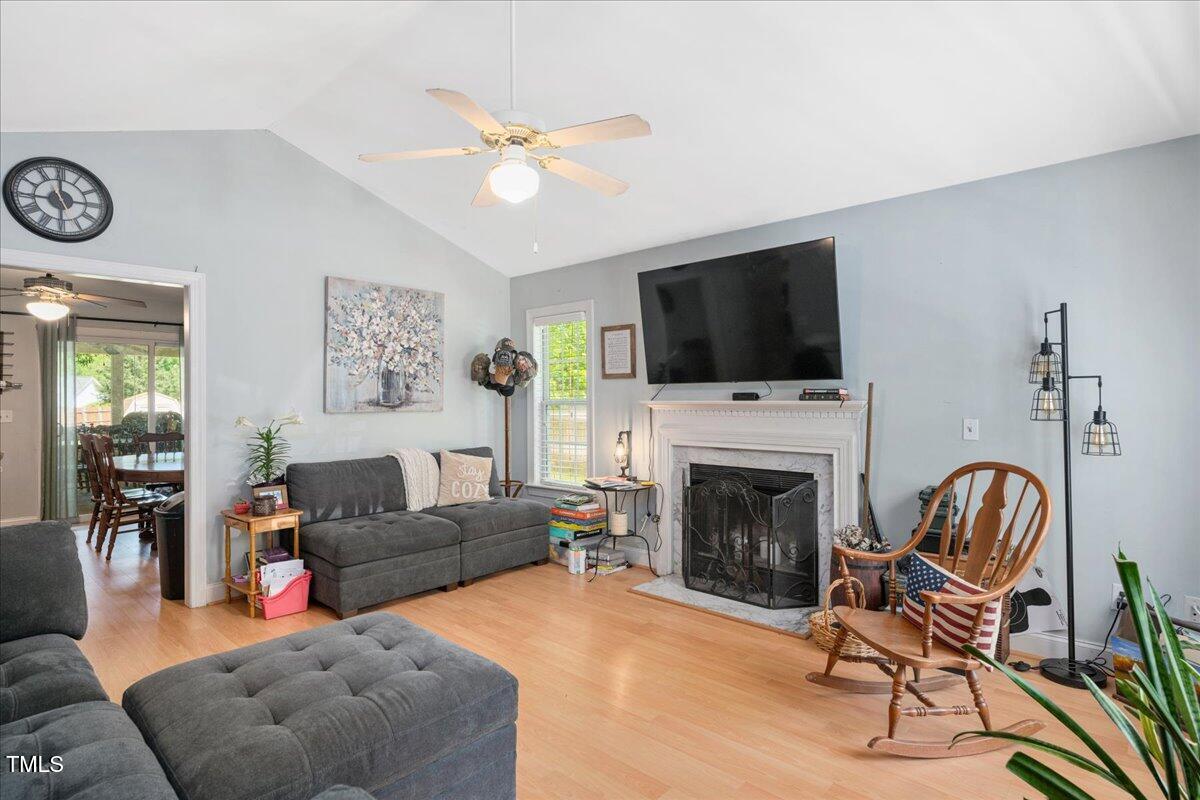 604 Sinewell Drive Wake Forest, NC 27587 - Photo 4 of 25 a living room with furniture a flat screen tv and a fireplace