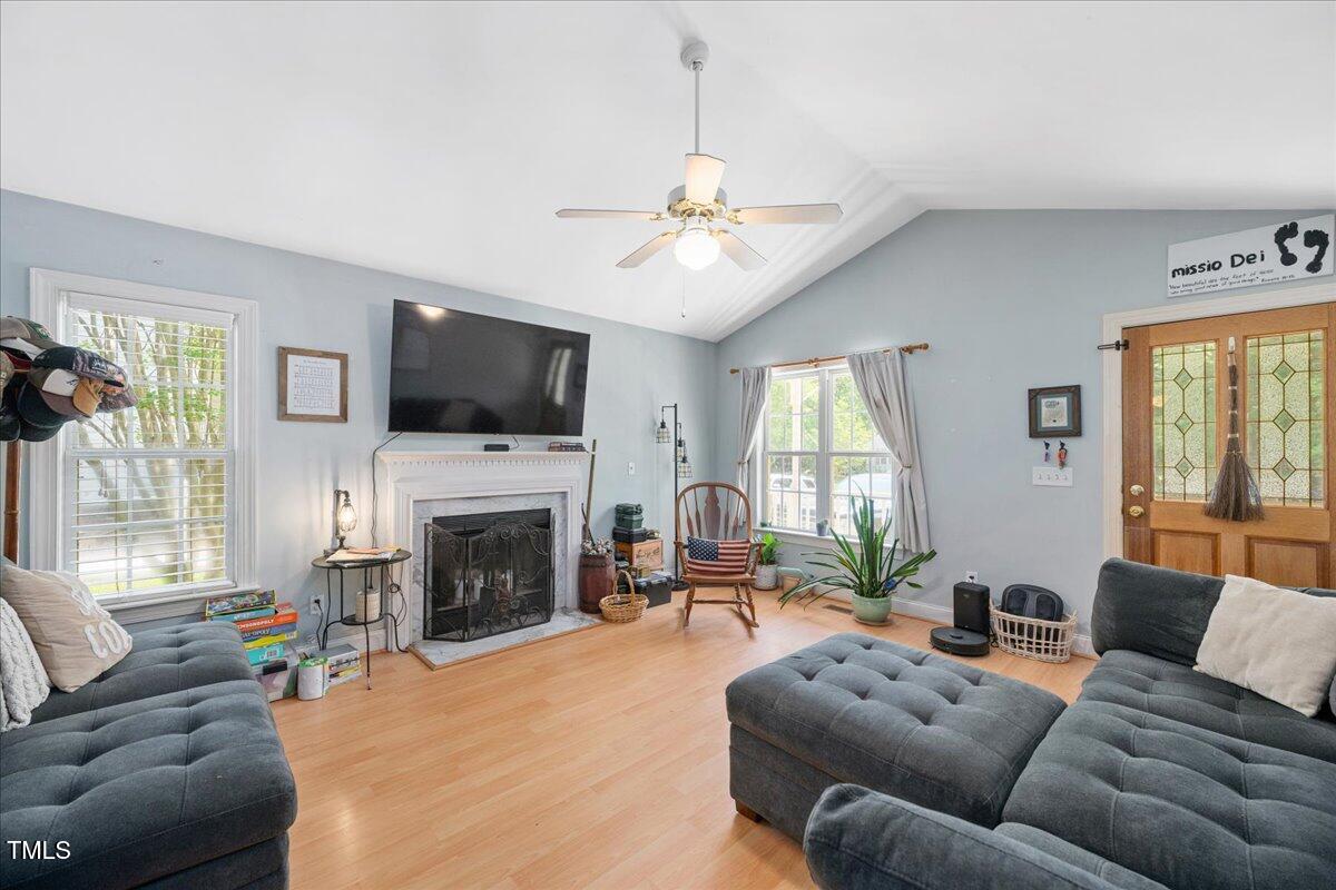 604 Sinewell Drive Wake Forest, NC 27587 - Photo 7 of 25 a living room with furniture a fireplace and a flat screen tv