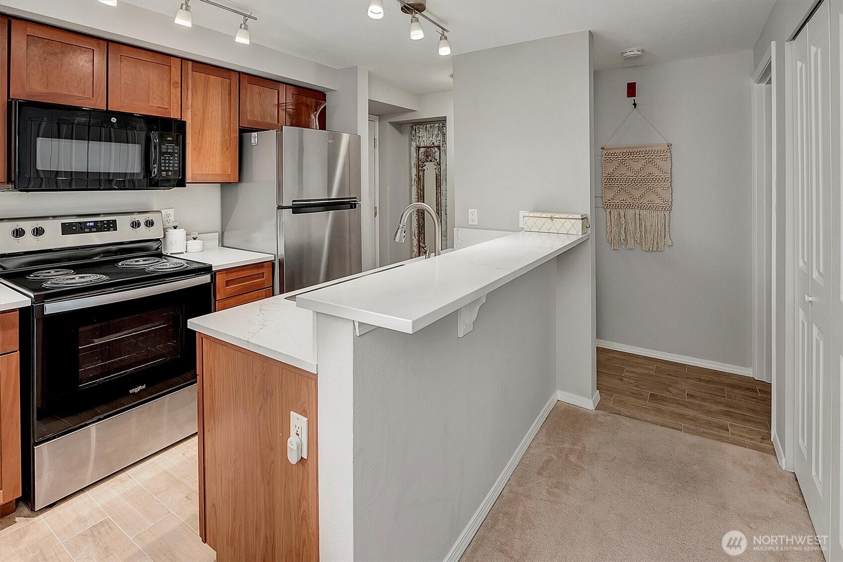 300 10th Avenue, Unit B205 Seattle, WA 98122 - Photo 8 of 27 a kitchen with stainless steel appliances a refrigerator and a stove top oven