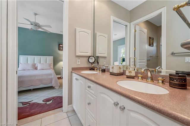 a en suite bathroom with a granite countertop sink and a mirror