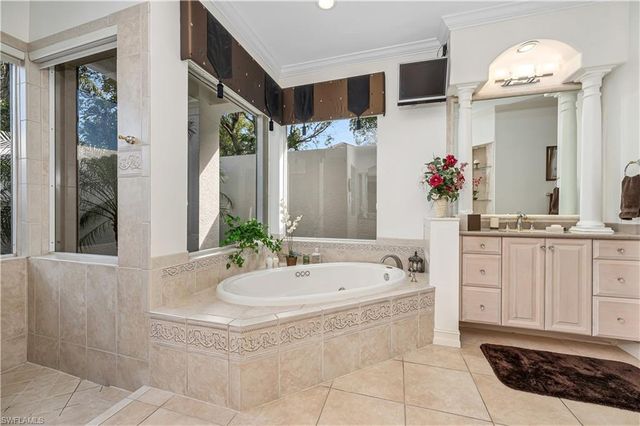 a bathroom with a tub sink and mirror