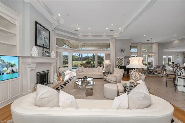 a living room with furniture fireplace and a large window