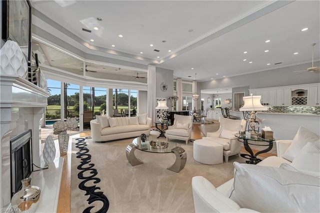 a living room with fireplace furniture and a large window