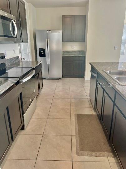31284 Penny Surf Loop Wesley Chapel, FL 33545 - Photo 6 of 15 a kitchen with granite countertop a refrigerator and a stove top oven