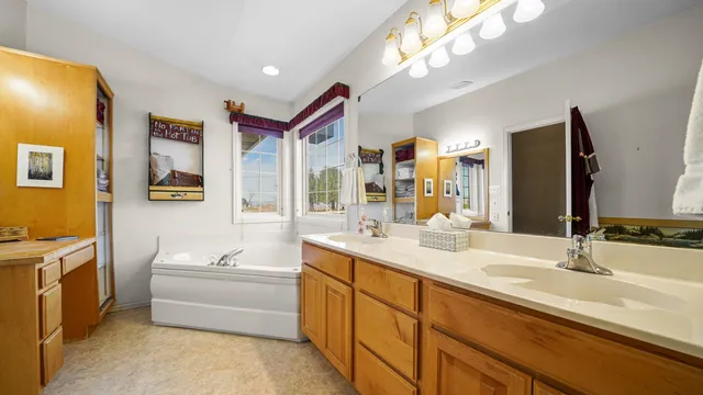 a bathroom with a double vanity sink mirror and bathtub