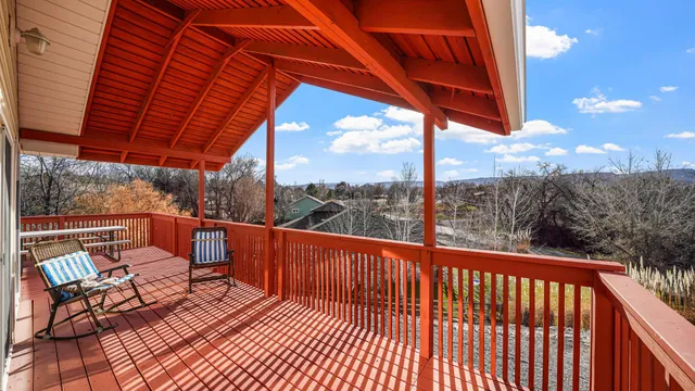 a balcony with wooden floor and outdoor seating
