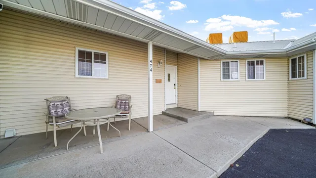 a front view of a house with a wooden chairs and table