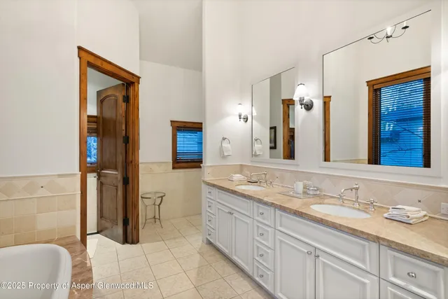 a spacious bathroom with a granite countertop tub sink and mirror